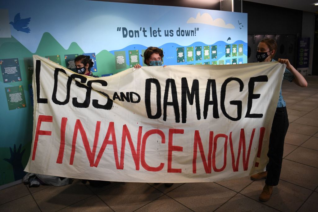Protestors hold a placard that reads: "Loss and Damage. Finance Now!"
